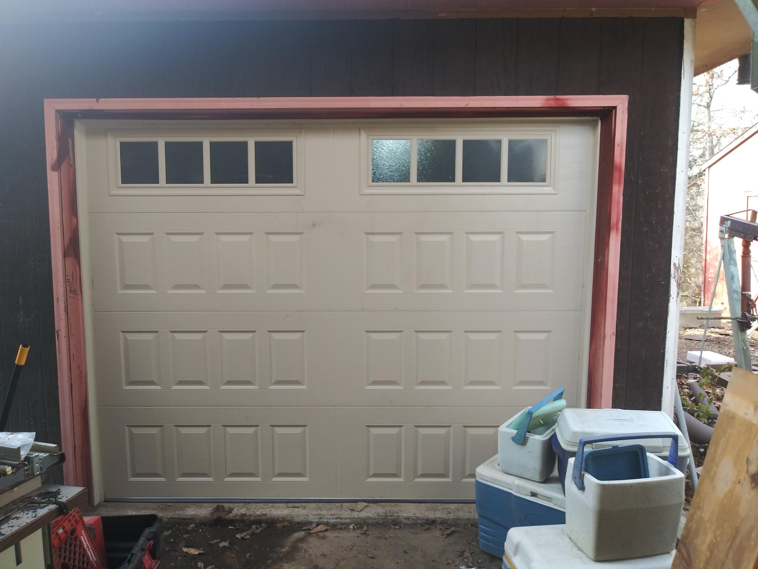 Technician replacing torsion spring on residential garage door